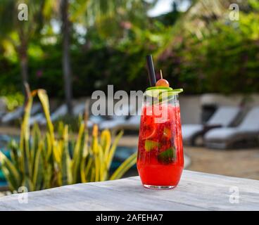 Glas Saft am Strand Tabelle im Sommer Tag. Stockfoto