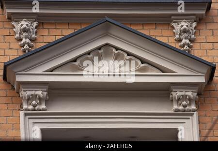 Eklektische Mietshaus arch Türen shell Lion's Head Relief old stone yellow brick Detail ornament Stockfoto