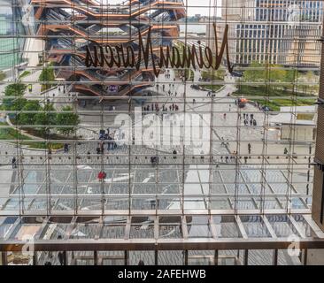 Gefäß aus Stahl Skulptur mit Menschen stehen, sichtbar von der Innenseite der Hudson Yards Mall, schoss durch die Rückseite einer Neiman Marcus Zeichen in der Stockfoto