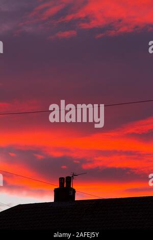 Feurigen Sonnenuntergang über Honley Dächer Stockfoto