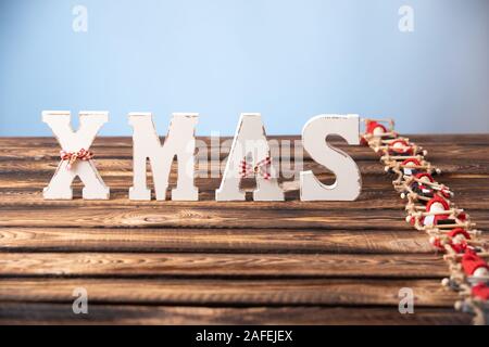 Holz- Buchstaben bilden Wort Weihnachten mit Bändern und roten Zahlen von Puppen neben Ihnen. die Puppe klettert die Strickleiter zu Buchstaben Stockfoto
