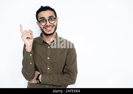Fröhlicher Kerl mit toothy Lächeln nach oben zeigen, während sie auf der Suche Stockfoto