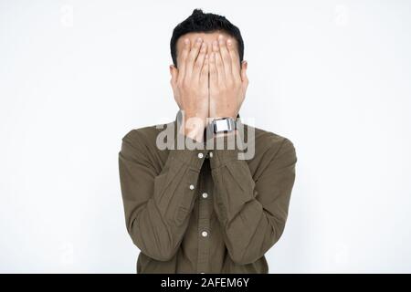 Junge Unternehmer bedeckte sein Gesicht mit der Hand beim Ausdrücken Ausfall Stockfoto