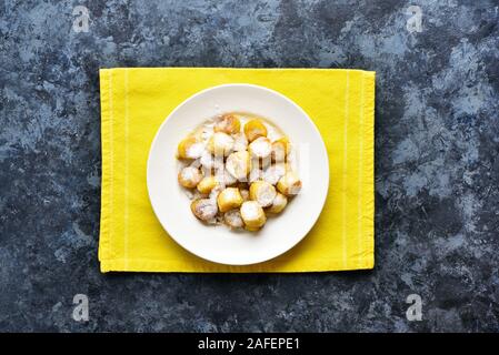 Banana fritters, frittierte Bananen in Scheiben geschnitten auf weißen Platte über der blauen Stein Hintergrund. Leckere Dessert von Gebratene Bananen im asiatischen Stil. Ansicht von oben, f Stockfoto