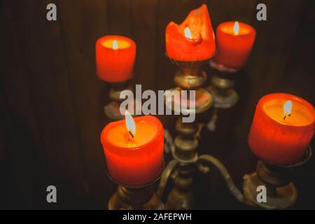 Fünf rote dicke Kerzen brennen in Vintage Bronze Leuchter. Stockfoto