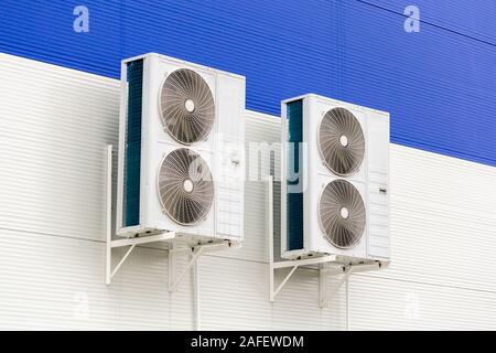 Zwei doppelte Verflüssigungssätze der Klimaanlage auf blau und Weiße Metallwand Stockfoto