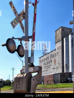Main Street Yukon Oklahoma Sport Yukon's beste Mehl Körnerelevator und ein Bahnübergang Signal und Arm. Stockfoto