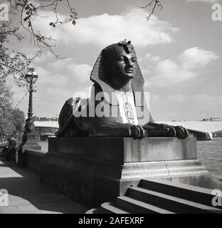 1950er Jahre, historisch, eine bronzene Sphinx-Statue - eine zwei - bei Cleopatra's Needle an der Einschiffung von Victoria neben der Themse, London, England, Großbritannien. Stockfoto