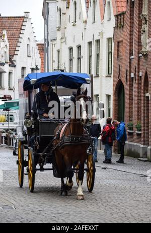 Brügge, Belgien - 28 April 2018: ein Pferd und Trap macht es Weg entlang der gepflasterten Straße von dijver Stockfoto