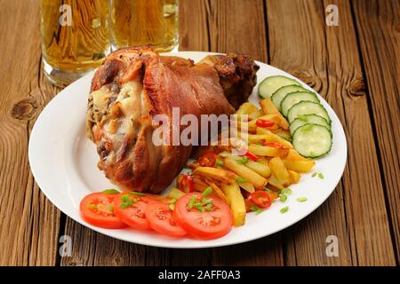 Eisbein mit Pommes frites, Gemüse und Bier closeup Stockfoto