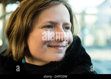 Dreißigjährige attraktive Frau posiert in der Straßenbahn Stockfoto