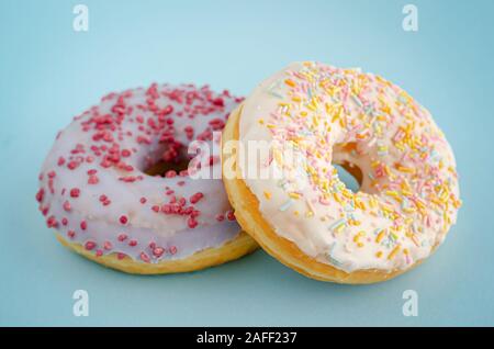 Traditionelle verglaste American Donuts auf Pastell-blaue Hintergrund. Close Up. Stockfoto