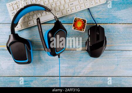 Gamepads Kopfhörer und Tastatur mit Maus auf altem Holz blau Tabelle Hintergrund. Stockfoto