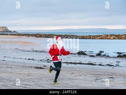 Frau in Santa run auf Beach, North Berwick, East Lothian, Schottland, Großbritannien Stockfoto