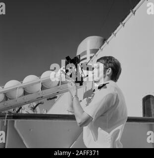 1960er Jahre, historisch, ein uniformierter Navigator draußen auf dem Deck eines Kreuzfahrtschiffes mit einem Sextant, einem maritimen Instrument, das zur Bestimmung des Winkels zwischen dem Horizont und einem Himmelskörper, wie der Sonne, verwendet wird, um Längen- und Breitengraden zu berechnen; um festzustellen, wo sich das Schiff befindet. Stockfoto