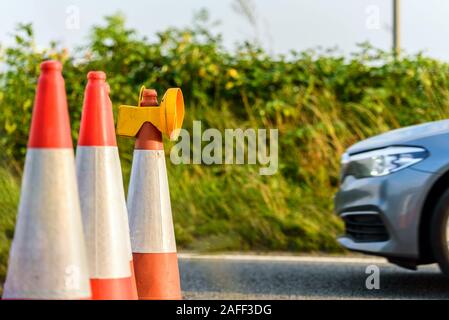 Sunset View uk Autobahn Dienstleistungen Baustellen Kegel mit Silver Auto vorbei Stockfoto