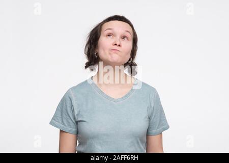 Junge Frau runzelte ihr Gesicht in Zweifel und Misstrauen Gefühl etwas skeptisch gegenüber. Menschliche Gefühle und Ausdrücke Konzept Stockfoto