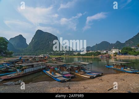 Yangshuo, China - August 2019: Kleine touristische und Fischer Boote auf dem Li Fluss Ufer, die Überfahrt mit der Fähre in Yangshuo Stockfoto