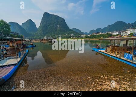 Yangshuo, China - August 2019: Kleine touristische und Fischer Boote auf dem Li Fluss Ufer, die Überfahrt mit der Fähre in Yangshuo Stockfoto