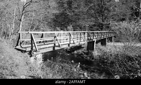 Alte Holzbrücke über den Fluss Dobra bei Kamačnik, im Herbst von blattlosen Wäldern umgeben Stockfoto