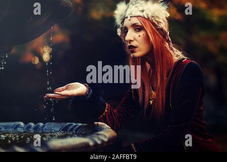 Schöne schamanische Frau mit Stirnband in der Natur. Stockfoto