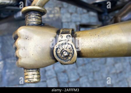 Uhr auf dem Arm einer Bronzestatue eines Jungen. Armbanduhr. Hand watch Clock. Fragment der Statue, Zeit. Stockfoto