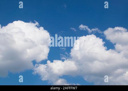 Fantastischen Panoramablick auf helle weiße Geschwollene cottony Wolken leuchten von Sun die Verbreitung gegen tief blauem Himmel bewegen mit Wind. Schönheit und Kraft von n Stockfoto