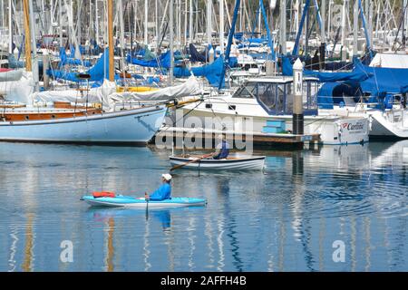 Ein Paddler und eine kanutin, Reisen in entgegengesetzte Richtungen an der Marina in den Hafen von Santa Barbara, Santa Barbara, CA Stockfoto