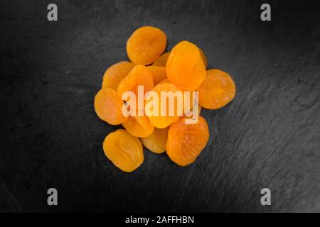 Teil der getrockneten Lebensmitteln (Aprikosen) als detaillierte Nahaufnahme auf einem Schiefer Tafel (selektive Fokus) Stockfoto