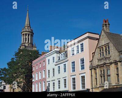 Oxford High Street, die Fassaden der kommerziellen Gebäude unter der Oxford Universität Gebäude, und der Turm der Kirche Stockfoto