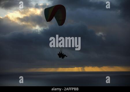 San Diego, Kalifornien, USA. 14 Dez, 2019. Tandem Gleitschirm fliegen über der Küste von La Jolla bei Sonnenuntergang nach dem Entfernen aus dem Torrey Pines Glider Port. Der Hafen wurde als hochfliegend Website im Jahre 1930 gegründet und ist die Heimat von Drachenfliegen, Paragliding, Funkgesteuerte Modell Segelflugzeuge und maßstäbliche Mann - Durchführung von Segelflugzeugen. Credit: KC Alfred/ZUMA Draht/Alamy leben Nachrichten Stockfoto