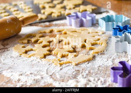 Gerollt Zucker Plätzchenteig mit Rolling Pin und Ausstechformen unscharf im Hintergrund. Selektive konzentrieren. Keine Menschen. Stockfoto