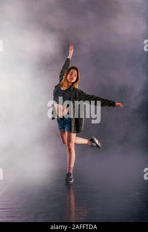 Tänzerin zeigt ihre Eleganz, indem sie ihr Bein hoch über den Kopf. Stockfoto