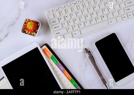 Arbeitsplatz mit Zusammensetzung pen, wöchentliche Notebook, Mobiltelefon, digitale Tablet und Computer Tastatur Stockfoto