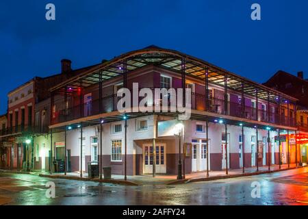 Historische Gebäude an der Ecke der Bourbon Street und St. Peter Street im französischen Viertel in der Nacht in New Orleans, Louisiana, USA. Stockfoto