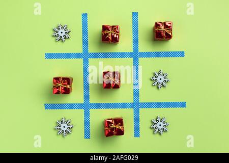Tic Tac Toe Spiel mit Weihnachten Spielzeug, auf grünem Hintergrund isoliert. Weihnachten, Winter Konzept. Flach, Ansicht von oben. Stockfoto