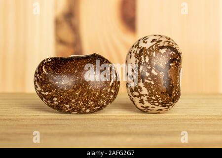 Gruppe von zwei ganze Gefleckte braune Bohne Pinto auf natürlichem Holz Stockfoto