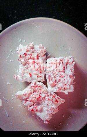 Marshmallows auf einem Teller mit zerquetschten Zuckerstangen Stockfoto