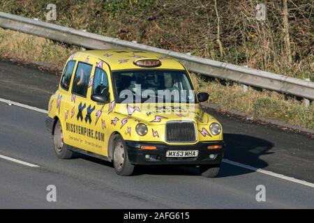 Missy Empire Yellow London Taxis Int Txii Bronze Autoi auf der Autobahn M61 in der Nähe von Manchester, Großbritannien Stockfoto