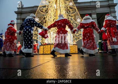 Moskau, Russland. 15. Dezember 2019 Leute in Vater Frost Kostüme führen eine Runde tanzen um den Weihnachtsbaum während der Vater Frost Festival in VDNKh in Moskau, Russland Stockfoto