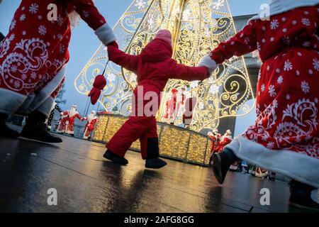 Moskau, Russland. 15. Dezember 2019 Leute in Vater Frost Kostüme führen eine Runde tanzen um den Weihnachtsbaum während der Vater Frost Festival in VDNKh in Moskau, Russland Stockfoto