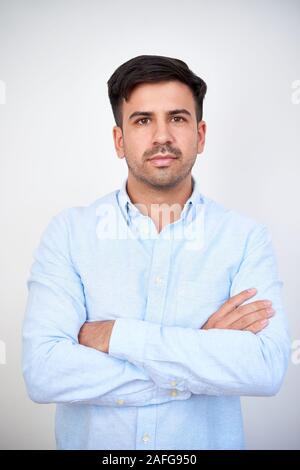 Portrait von Stattlichen ernsthafte junge Unternehmer zuversichtlich Falten Arme und Kamera Stockfoto
