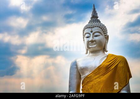 Eine schöne alte weiße Buddha Statue mitten in den Strahlen der Sonne durch die Wolken im Himmel. Es ist Platz für Nachrichten, die Sie auf Com möchten Stockfoto
