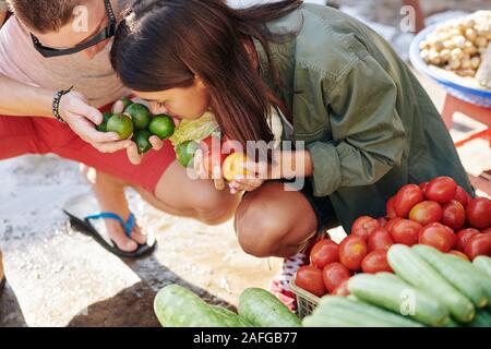 Junger Mann, Freundin reif frische Limonen zu riechen, wenn Sie Ihren Einkauf bei lokalen Markt sind Stockfoto