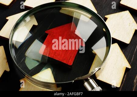 Immobilien Bewertung für Steuer- und verkaufen. Holz- häuser und Lupe. Stockfoto