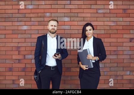 Geschäftsleuten stehen auf dem Hintergrund einer Mauer. Stockfoto