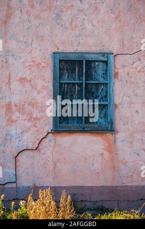 Vertikale Nahaufnahme eines blauen Fensters eines alten Verlassenes Haus Stockfoto