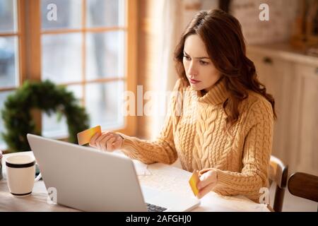 Dunkelhaarige junge Frau in Pullover Verwirrung Stockfoto