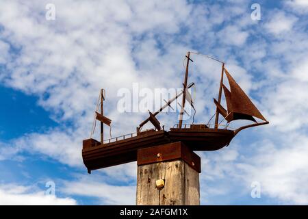 Eine Skulptur eines verrosteten hölzernen Segelbootes im Freien sitzt auf einem Holzpfahl am Port Germein Steg in Südaustralien Stockfoto