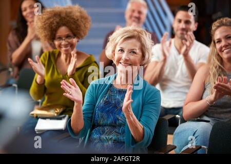 Gruppe die Teilnahme an Nachbarschaft Treffen applaudieren Lautsprecher im Community Center Stockfoto